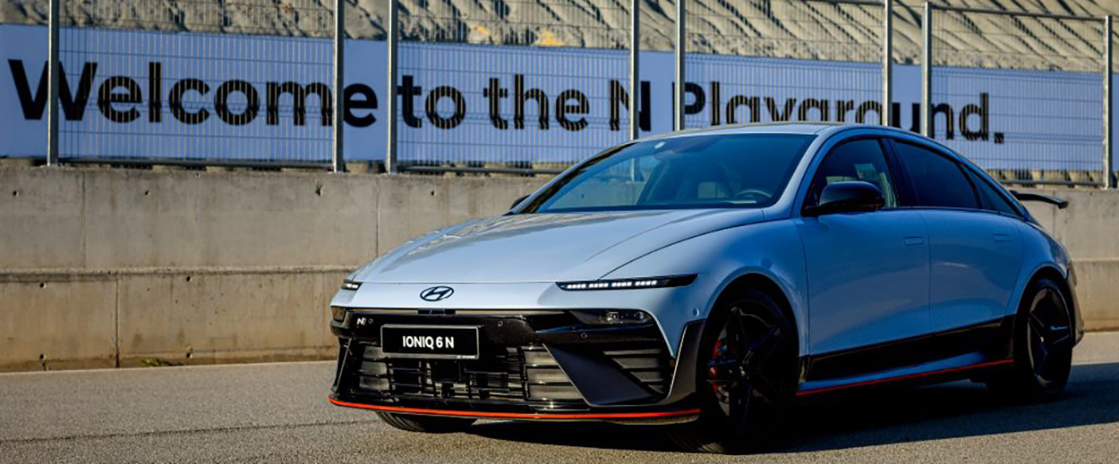 Berline électrique Hyundai IONIQ 6 N bleue sur un circuit avec panneau Welcome to the N Playground en arrière-plan