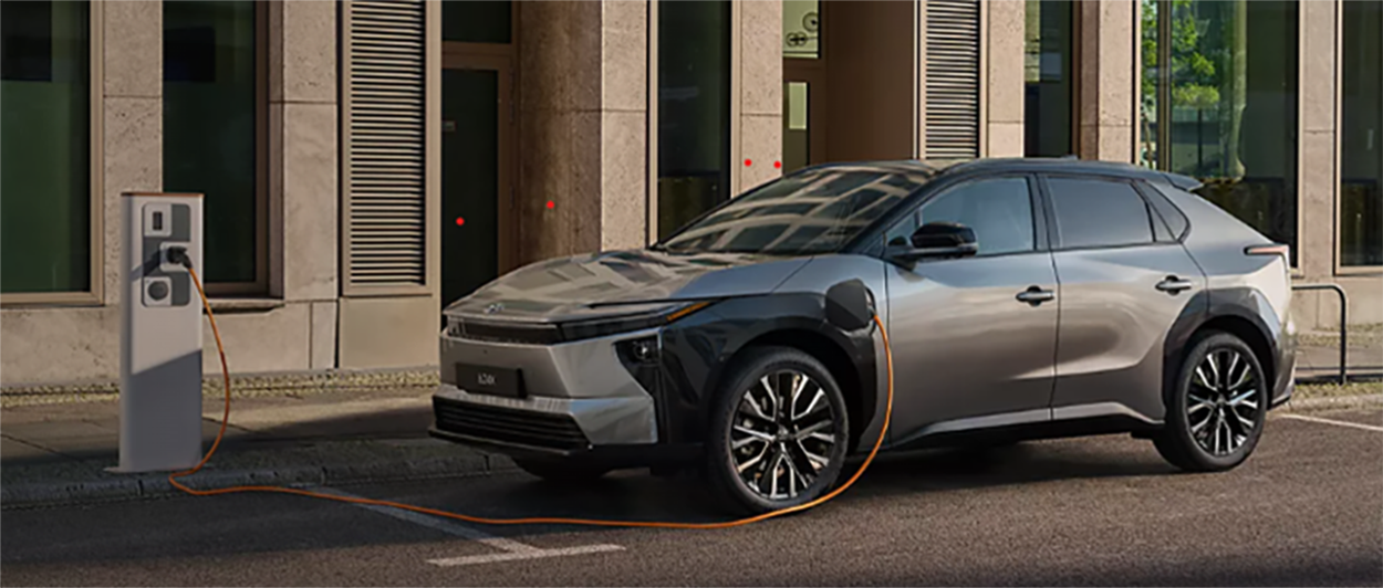Toyota bZ4x stationné devant une borne de charge