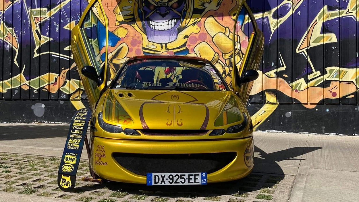 206 de Sissou jaune de face devant un mur tagué