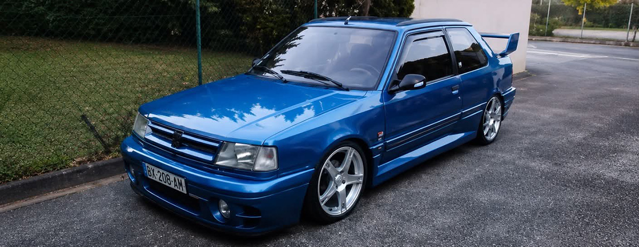 309 GTI Bleue devant une pelouse
