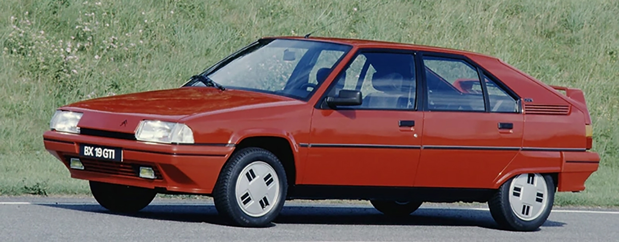 Citroën BX 19 GTI (1986) rouge vif : la berline sportive française légendaire, vue de profil.