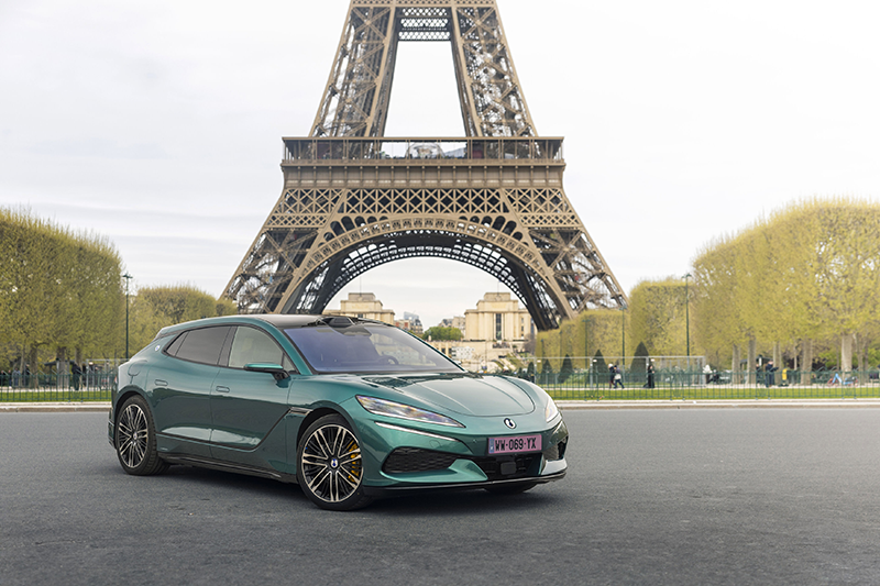 photo de la nouvelle DENZA Z9GT, break de chasse électrique haute performance de couleur sombre,stationnée devant la Tour Eiffel