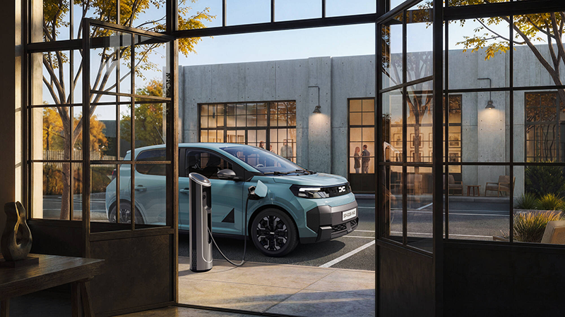 Nouvelle Dacia Spring derrière une verrière en station de charge
