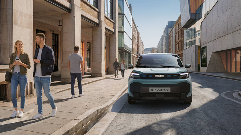 Nouvelle Dacia Spring face avnt stationnée dans une rue avec des passants