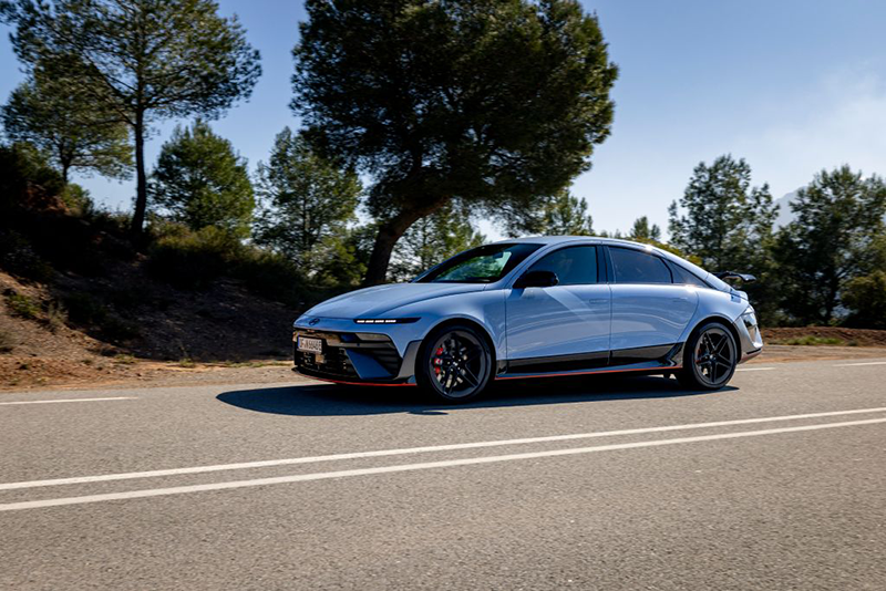 hyundai ioniq 6 n vue latérale sur route devant un bouquet d'arbres