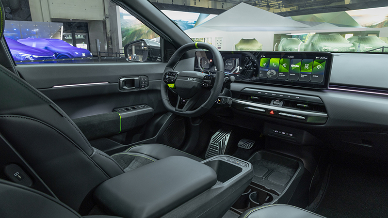Vue intérieure du cockpit technologique de la Kia EV4 GT, montrant le triple écran panoramique ccNC,