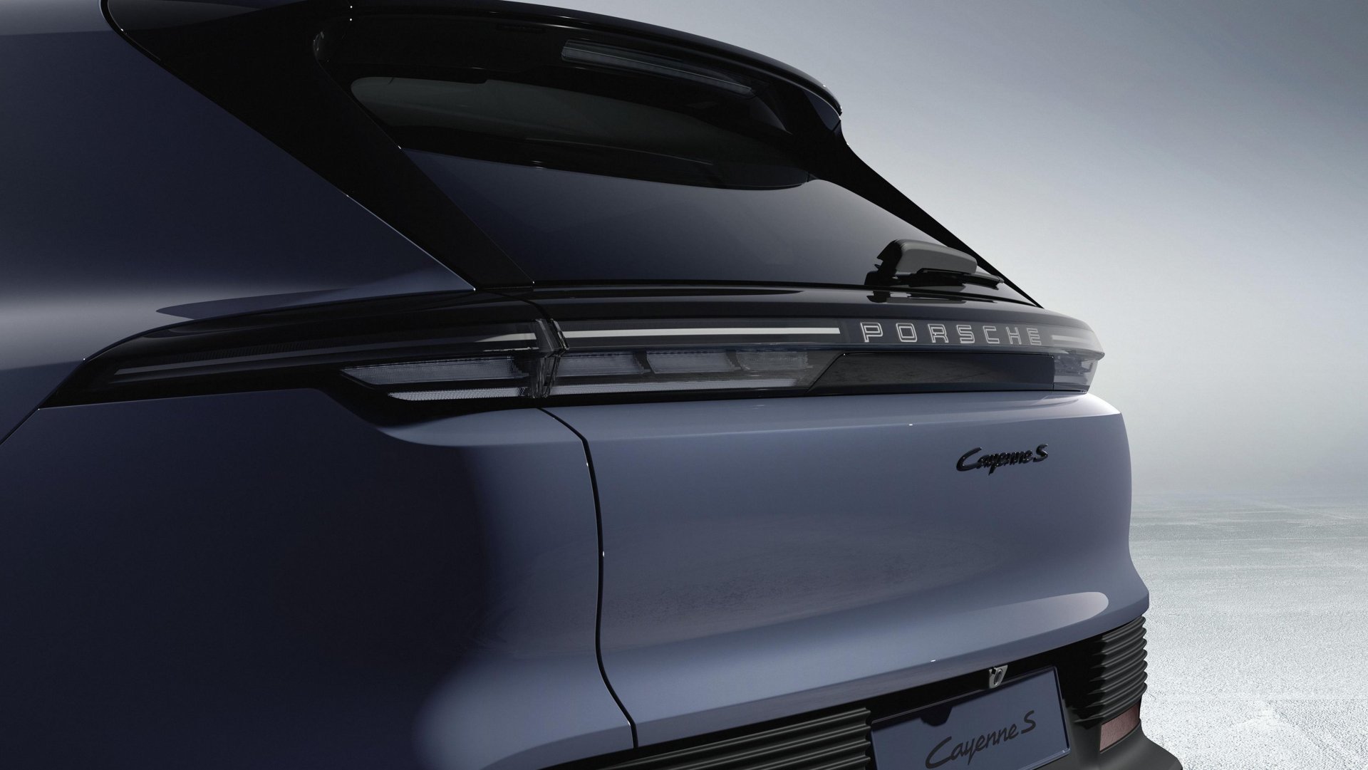 Vue arrière dynamique du nouveau Porsche Cayenne S Electric gris, soulignant le bandeau lumineux continu