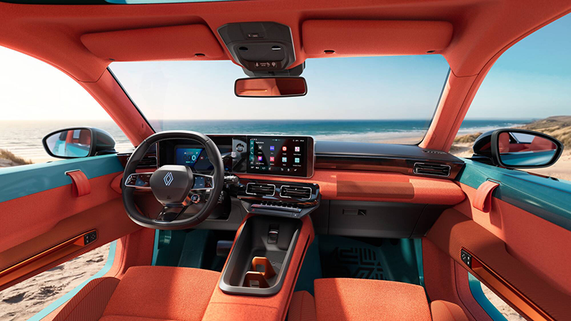 Vue de l'habitacle de la Renault 4 JP4x4 Concept avec sa sellerie orange pop, sa planche de bord en textile et sa console centrale flottante face à la mer.