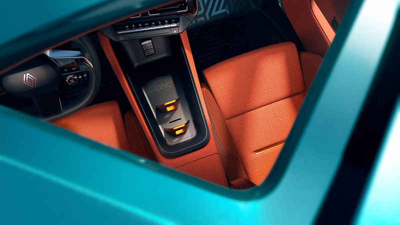Vue plongeante sur la console centrale flottante et les sièges baquets orange de la Renault 4 JP4x4 Concept, soulignant la sellerie en tissu et le logo JP4.
