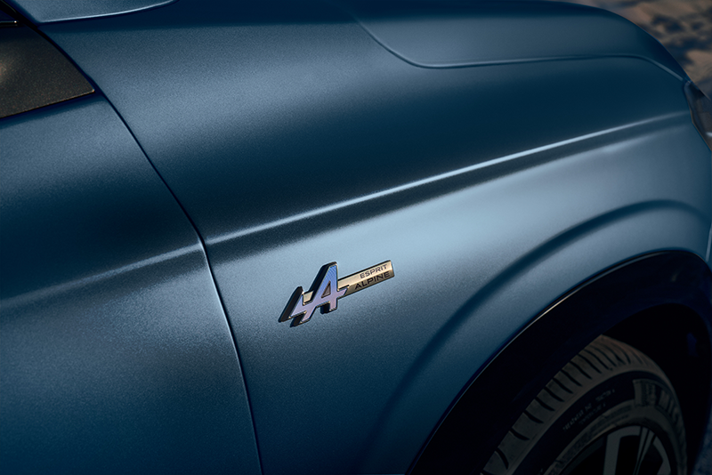 Zoom sur le badge latéral Esprit Alpine avec logo fléché bleu, positionné sur l'aile avant d'un Renault Austral ou Rafale