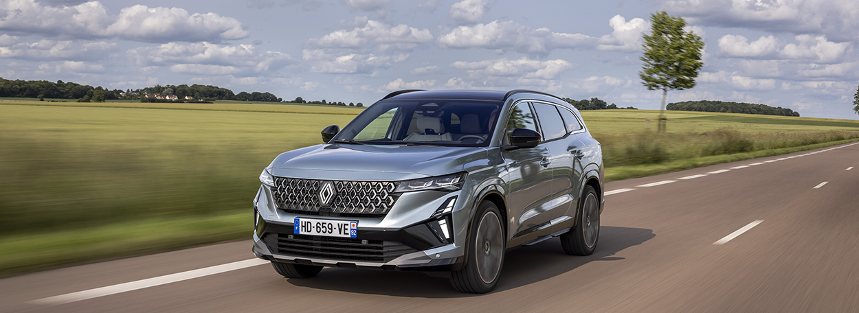 Renault Espace full hybrid E-Tech 200 ch en finition Iconic, couleur Gris bleuté Baltique, en circulation sur une route sinueuse. Modèle 2026