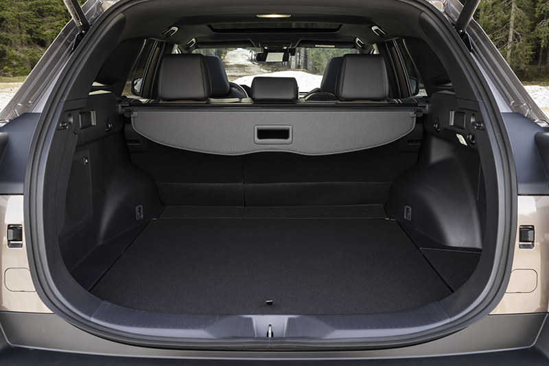 Vue arrière du coffre ouvert du Toyota bZ4X Touring 2026 AWD coloris Bronze, révélant un volume de chargement de 669 litres, seuil de chargement plat et barres de toit de série.