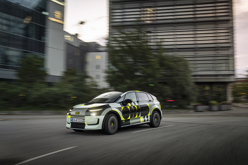 Audi A2 e tron  en ville devant des bâtiments