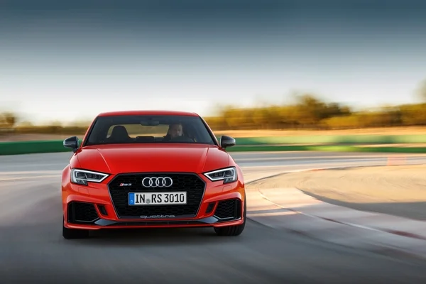 Audi RS 3 berline rouge sur une route