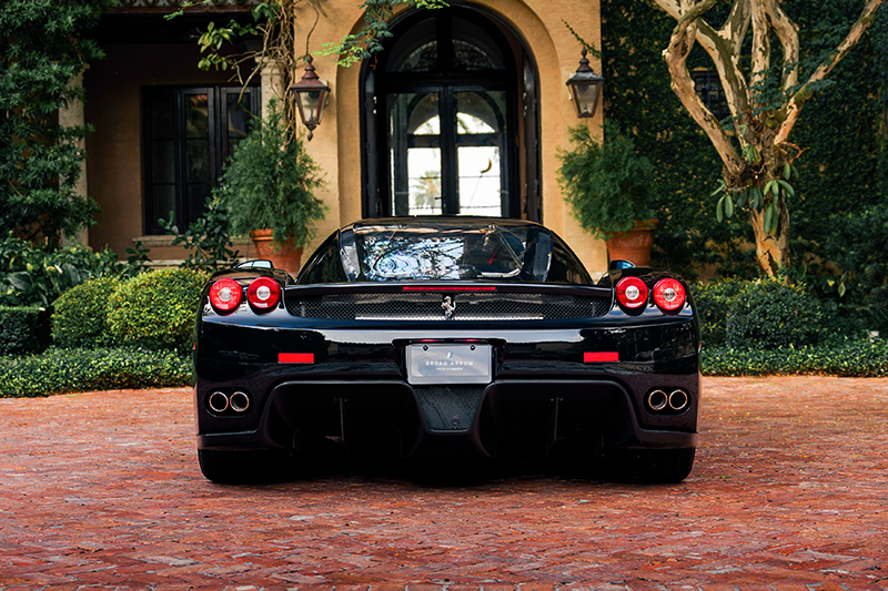 Arrière de la Ferrari Enzo noire Nero DS avec V12 visible et quatre sorties d'échappement