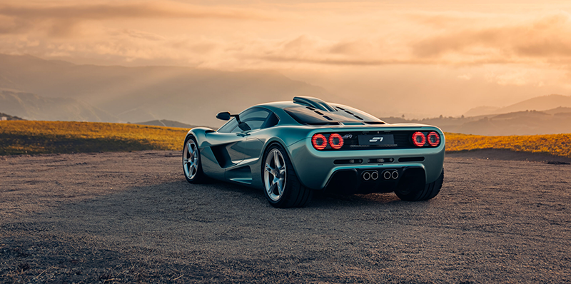 Vue arrière de la Gordon Murray S1 vert métallisé avec feux ronds et quadruple sortie d'échappement au coucher du soleil