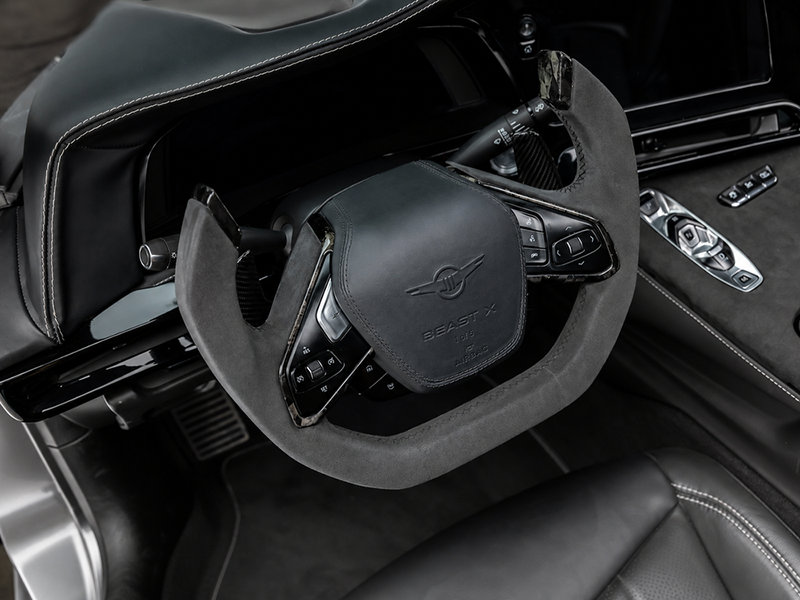 Gros plan sur le volant de style 'yoke' de la Rezvani Beast X, gainé d'Alcantara gris avec des détails en fibre de carbone et le logo 'BEAST X'. Option 2 : Plus technique
