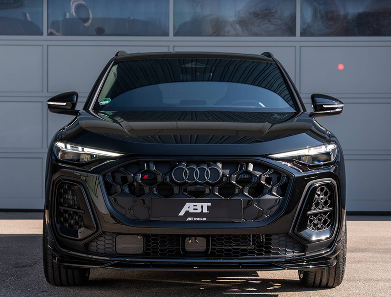 Face avant agressive de l'Audi SQ5 Sportback ABT gris nardo montrant le spoiler avant sport, la calandre noire mate et les jantes alliage 22 pouces.