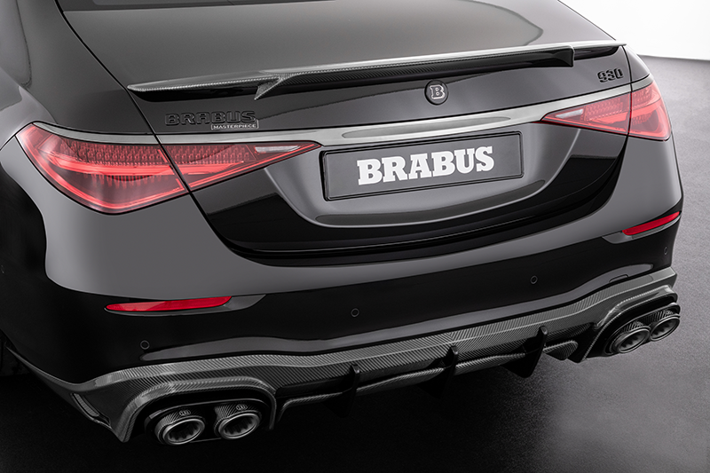 Zoom sur la double sortie d'échappement sport en titane et le diffuseur en fibre de carbone d'une Mercedes préparée par Brabus. Vue arrière basse et agressive.